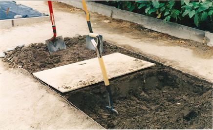 First Image: A bed of the correct dimensions, being prepared using digging board (for standing on while digging), D-handled Shovel for digging, and a spading fork for loosening the soil in the trench (shown with tines buried in the soil). Second Image: A group of GROW BIOINTENSIVE workshop participants getting hands-on practice double-digging.